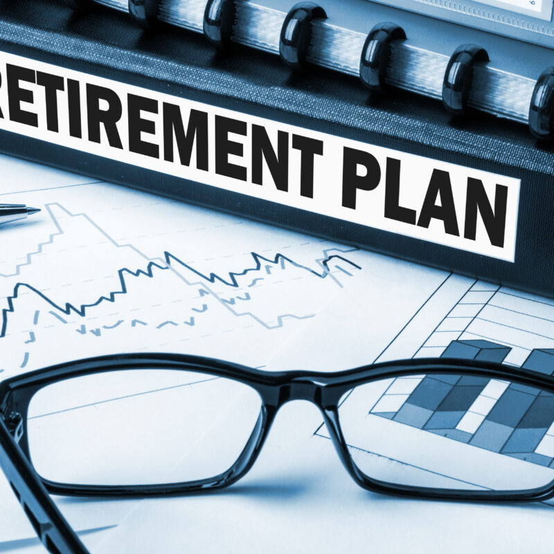 Folder labeled retirement plan with pen and glasses on top of stock paperwork | New Direction Family Law