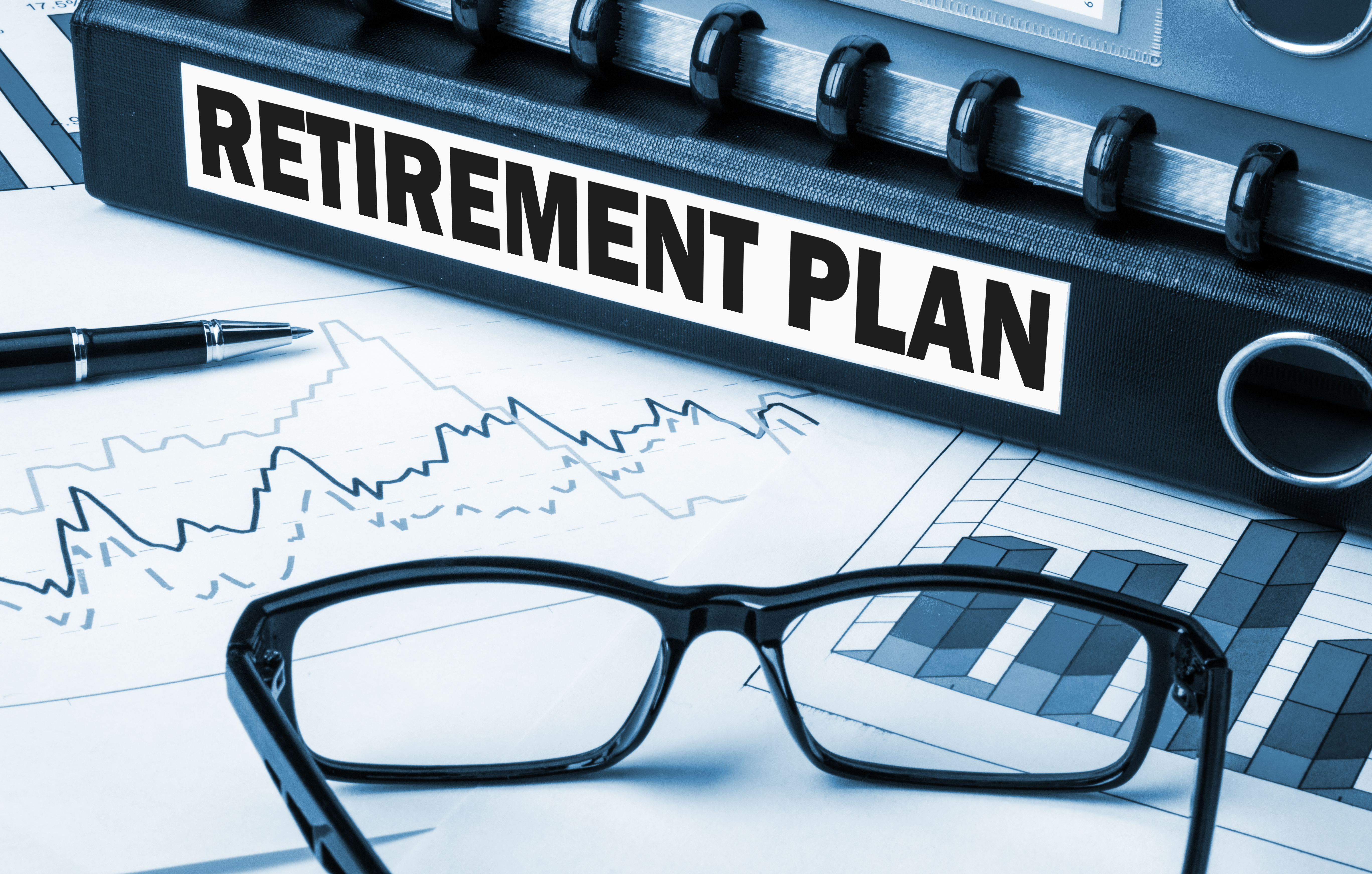 Folder labeled retirement plan with pen and glasses on top of stock paperwork | New Direction Family Law