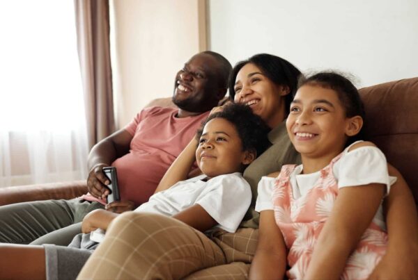 Family-Sitting-together-on-sofa-laughing | New Direction Family Law