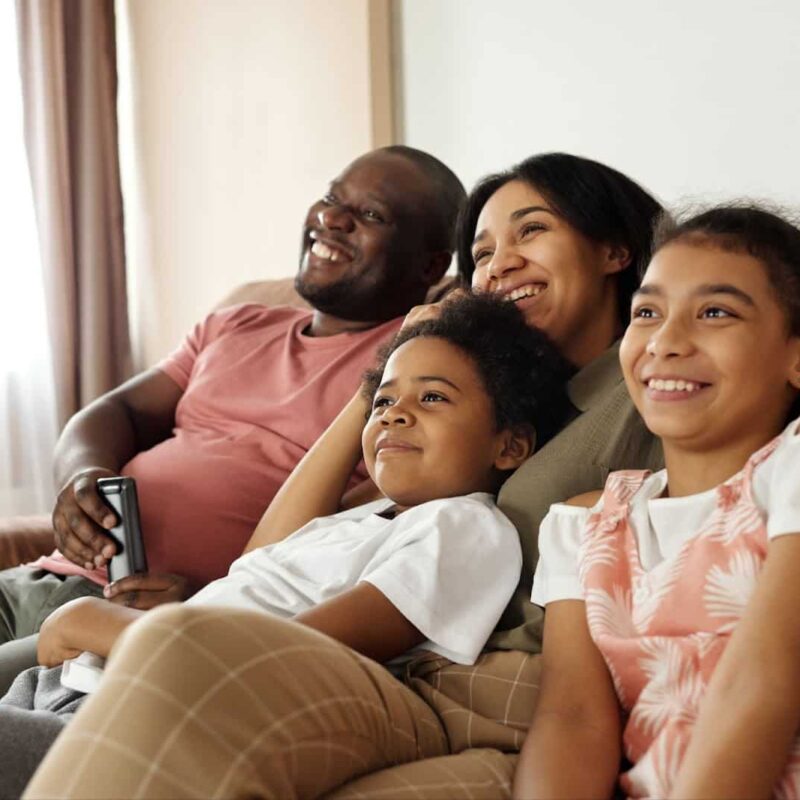 Family-Sitting-together-on-sofa-laughing | New Direction Family Law