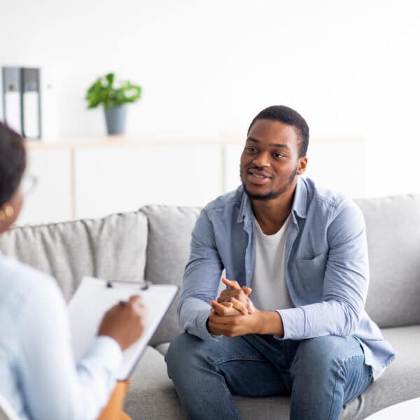 Man speaking with therapist while sitting on sofa | New Direction Family Law