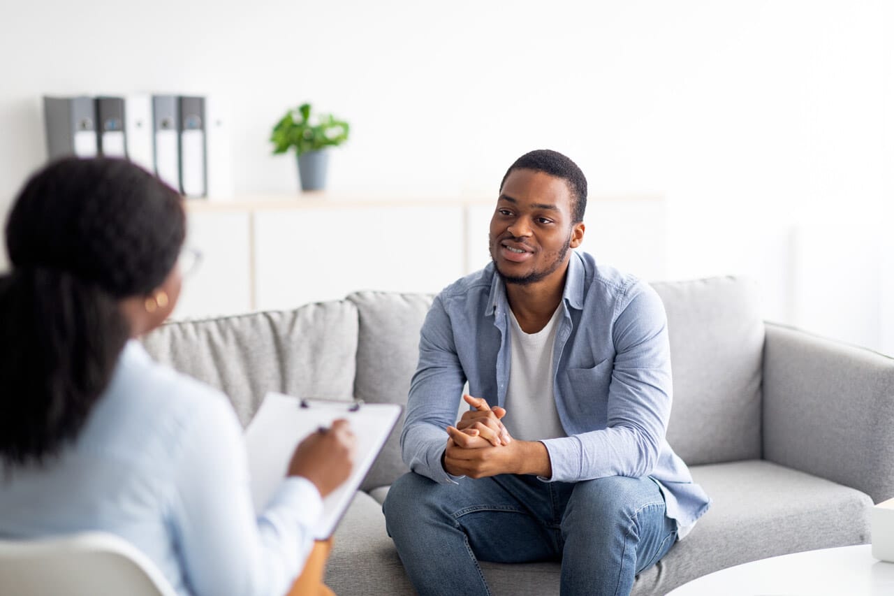 Man speaking with therapist while sitting on sofa | New Direction Family Law