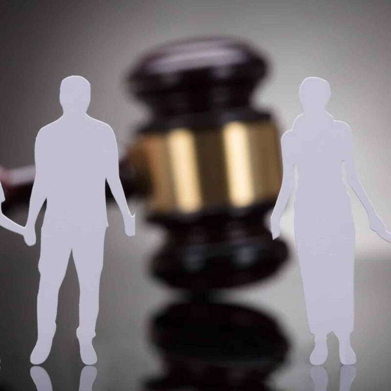 Separation of family figure cut away from gavel on grey background | New Direction Family Law