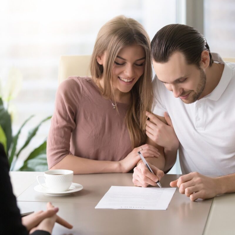 Couple signing prenuptial agreement | New Direction Family Law