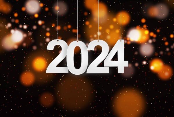A 2024 sign dangling in front of New Year’s lights and confetti. | New Direction Family Law