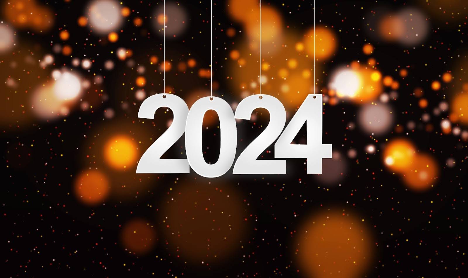 A 2024 sign dangling in front of New Year’s lights and confetti. | New Direction Family Law