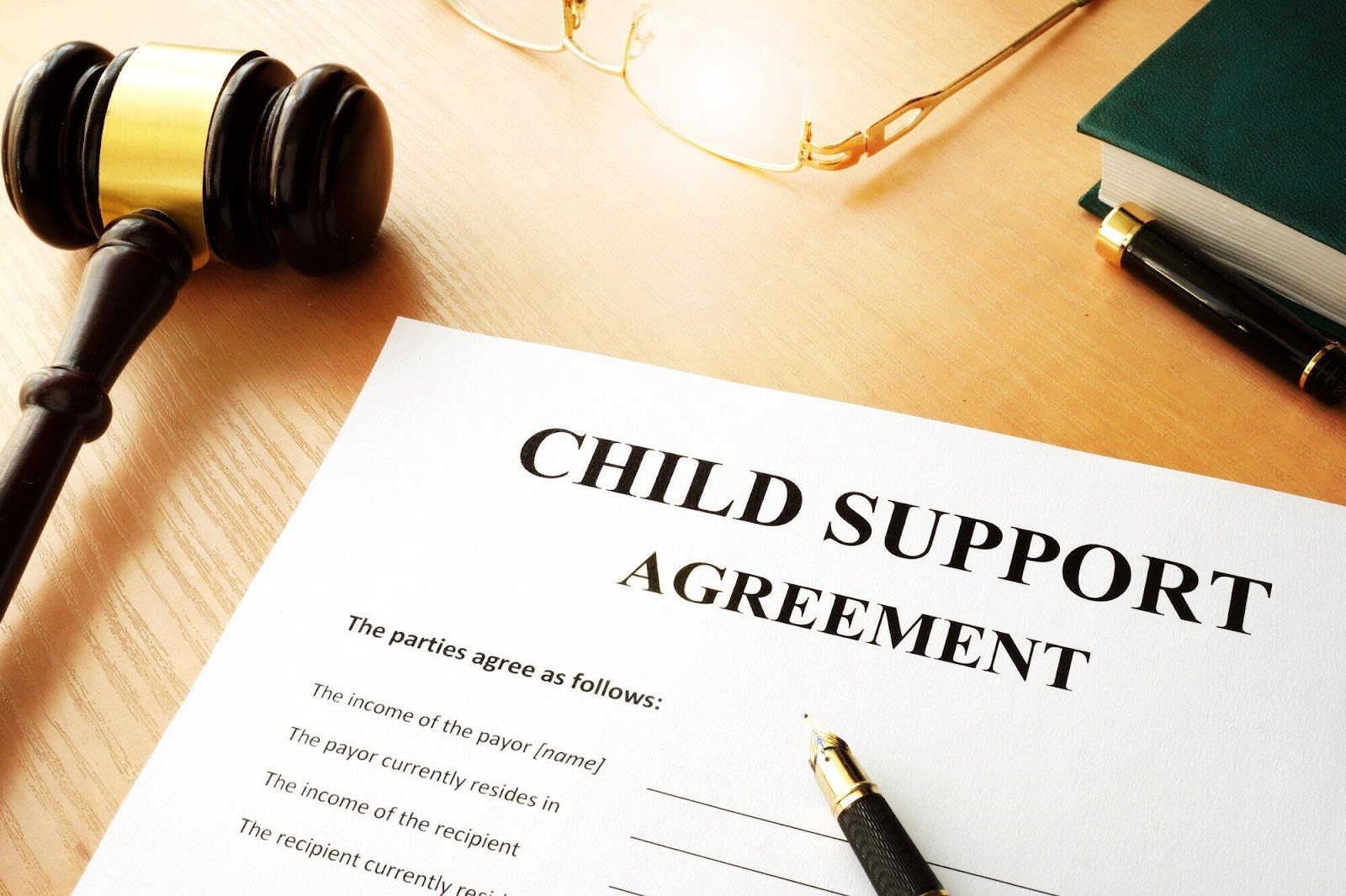 View of child support agreement with pencil to sign. | New Direction Family Law