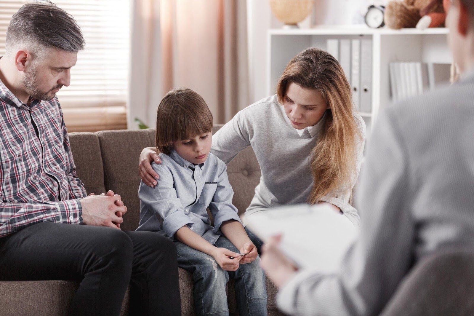 Young child being consoled by mom and dad. | New Direction Family Law