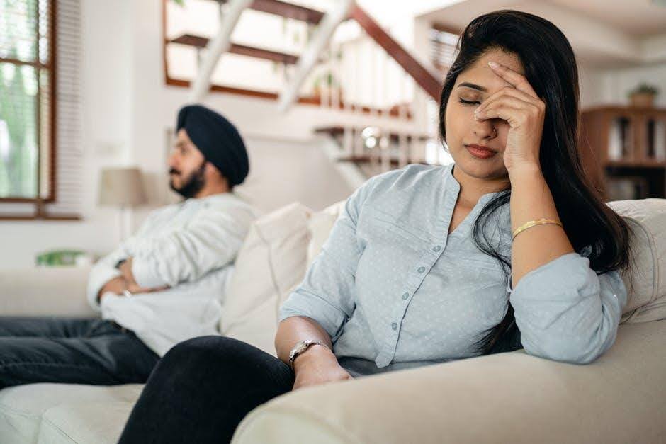 Couple sits on sofa considering divorce | New Direction Family Law