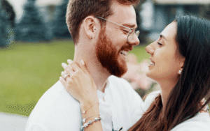 engaged couple embraces for picture while thinking about a prenuptial agreement in NC