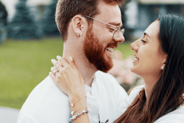 engaged couple embraces for picture while thinking about a prenuptial agreement in NC
