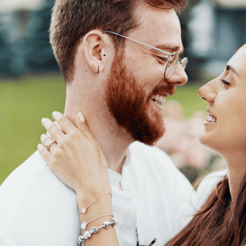engaged couple embraces for picture while thinking about a prenuptial agreement in NC